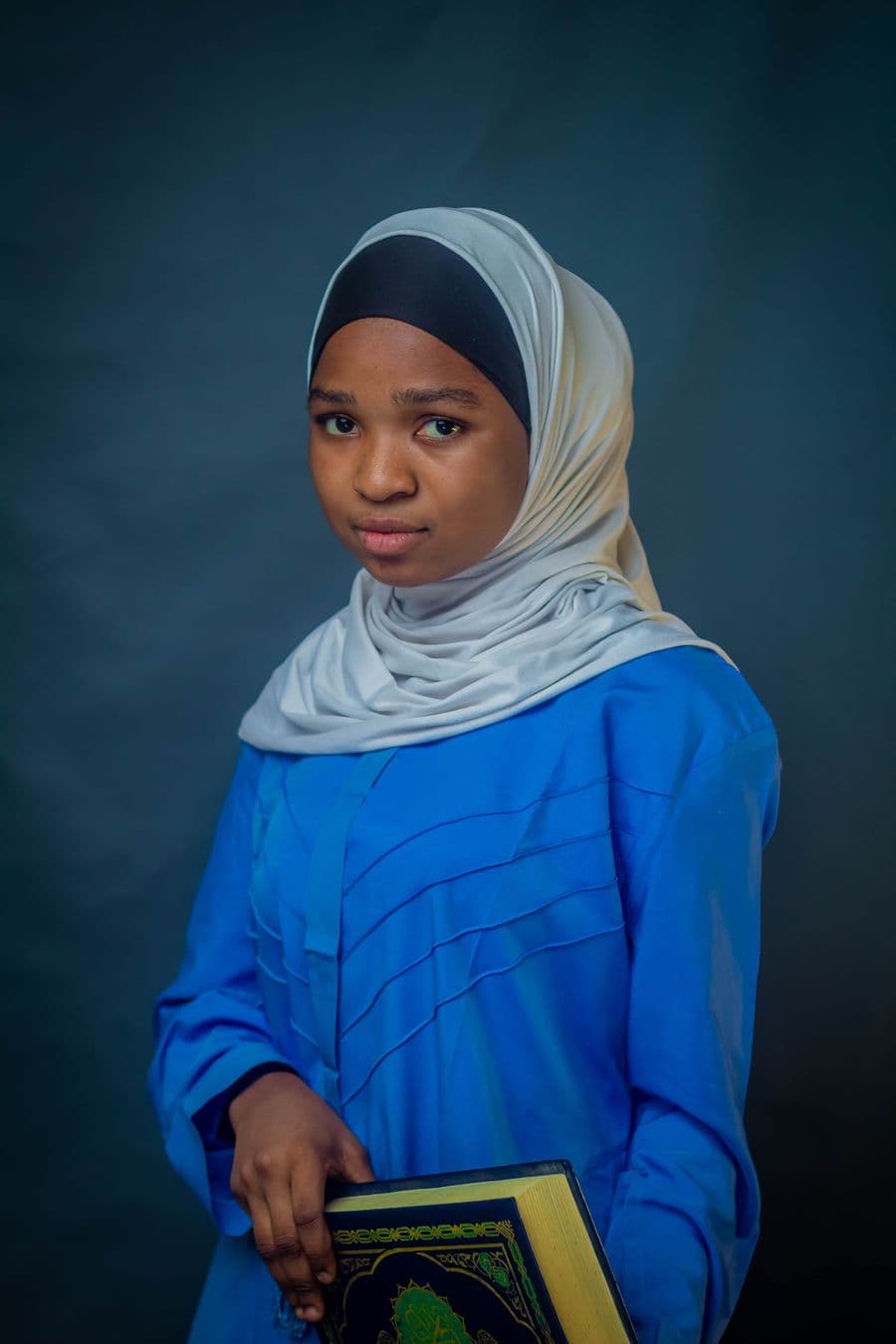 Genius Khalifah Academy student in hijab holding the Qur'an